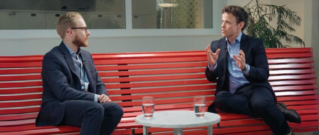 Founders video - Chris Sampson and Andrew Smith sitting on a red bench chatting