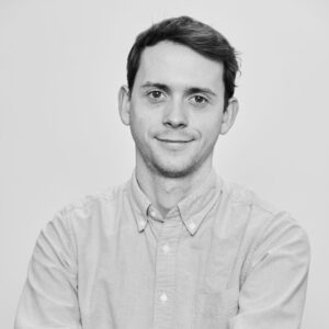 Head and shoulders portrait of man with short dark hair smiling at camera