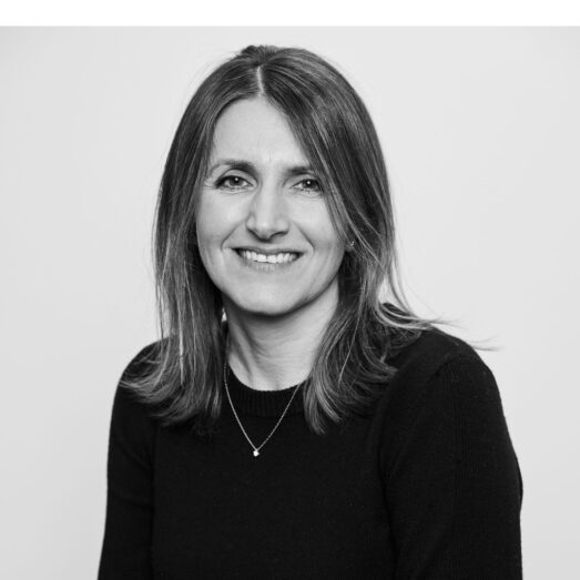 Portrait of a woman with shoulder-length dark hair smiling at the camera